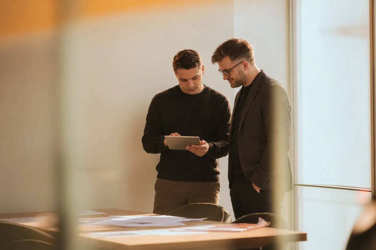 Two Humbleteam leads reviewing work on a tablet in the Dubai office