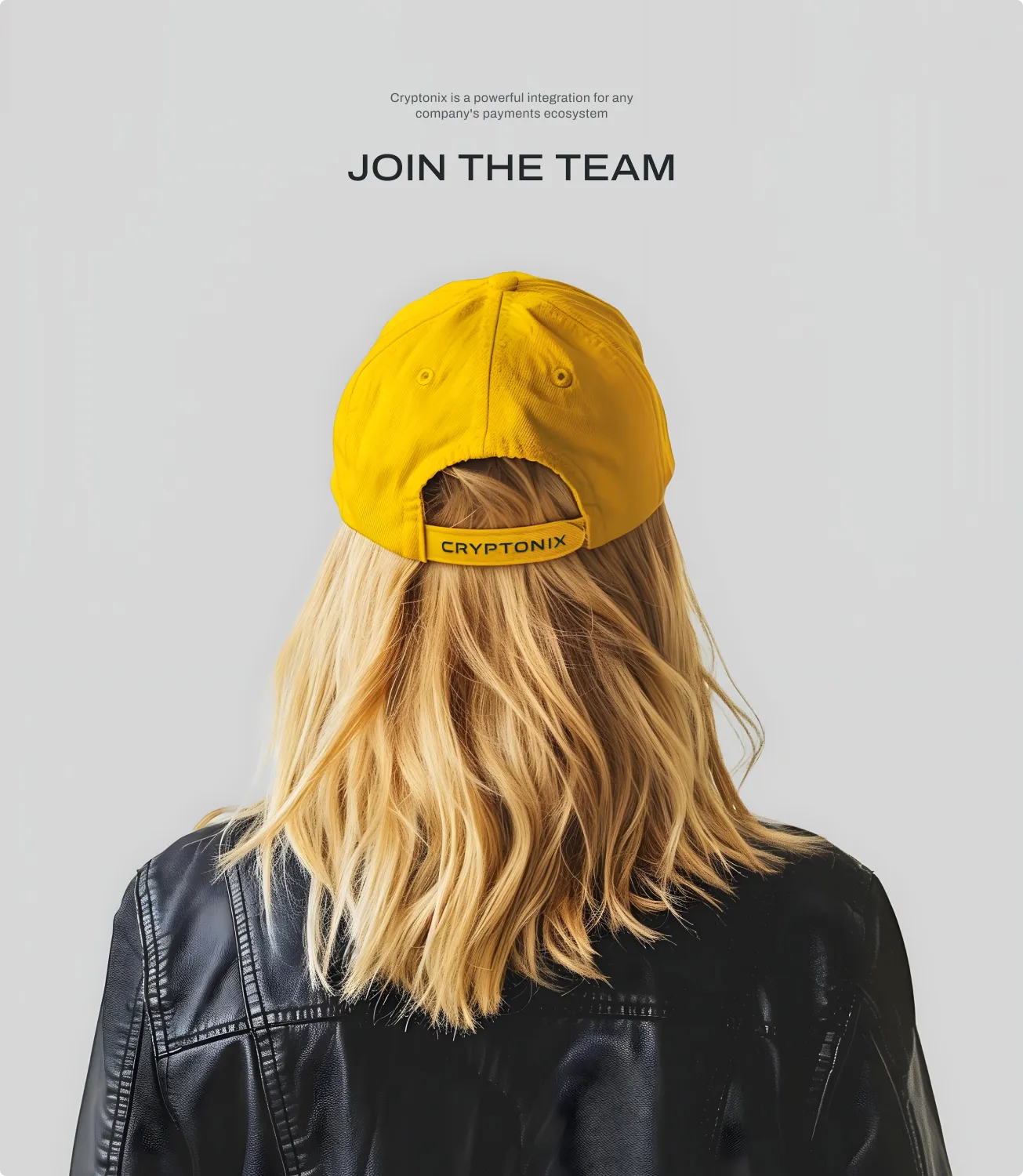 Woman seen from behind in a yellow Cryptonix branded cap — join the team