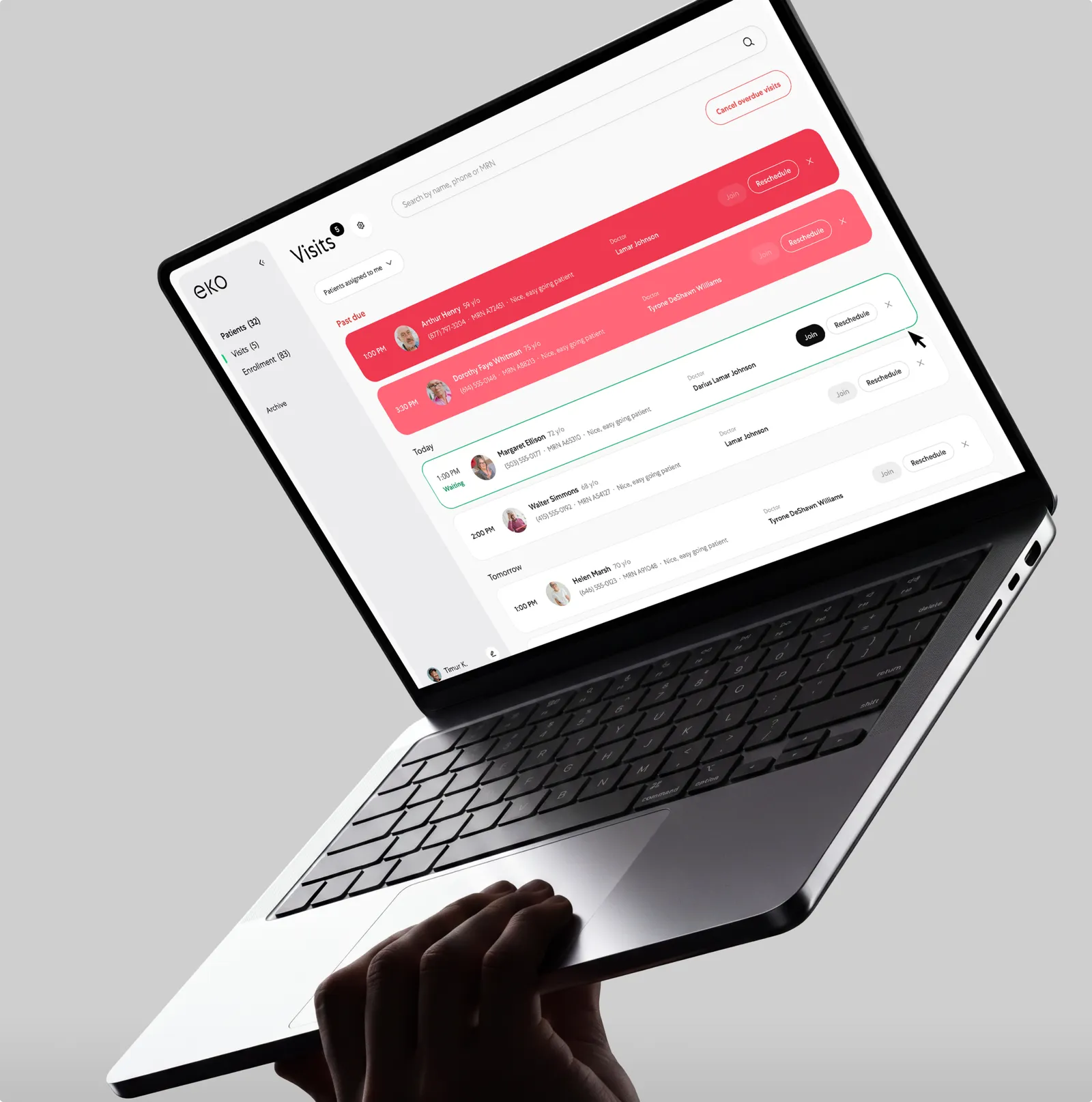 Laptop held in a hand showing the Eko Visits dashboard — a scheduled patient-visit list — on a light gray background