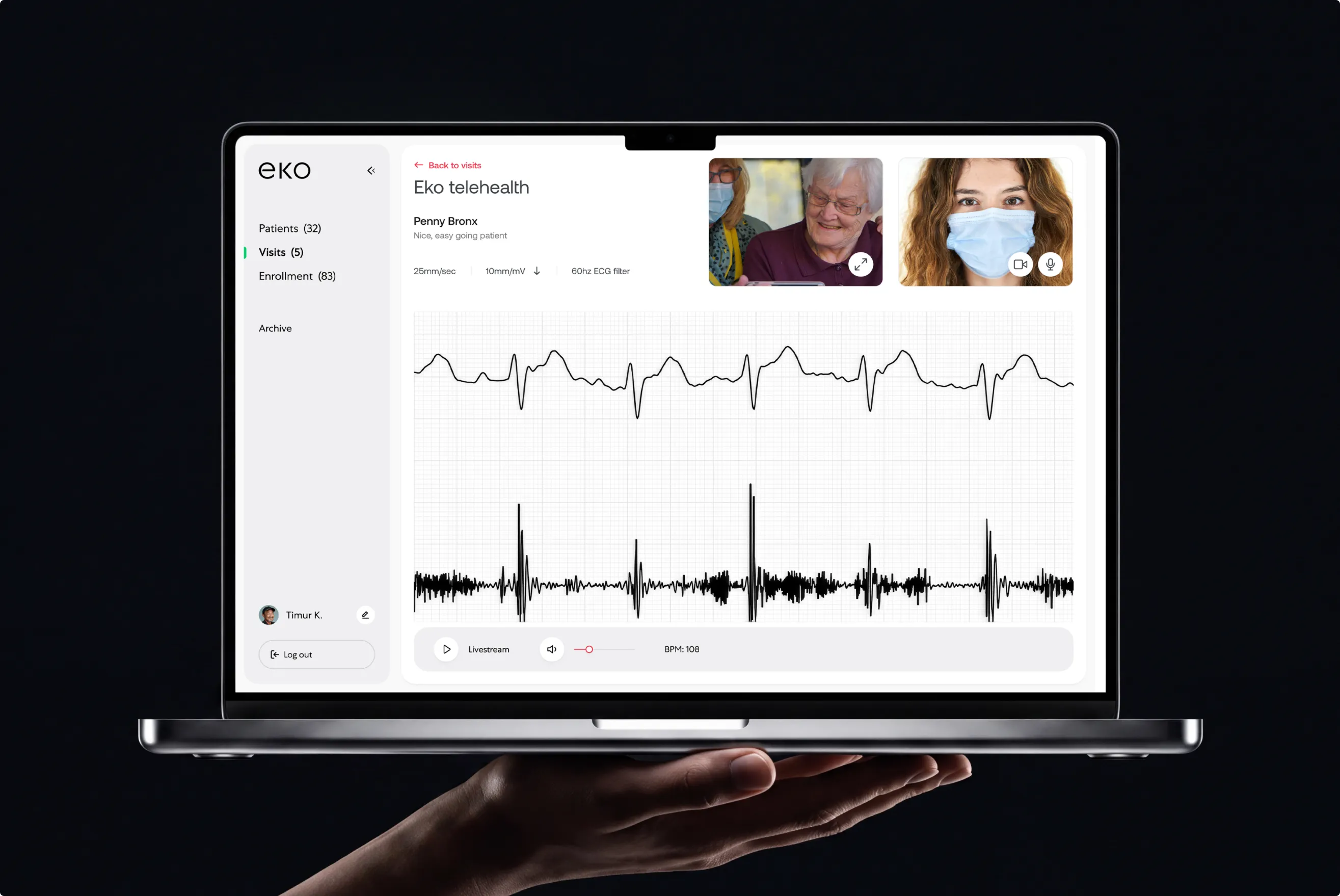 Laptop held in a hand showing the Eko telehealth session for patient Penny Bronx with two video thumbnails and a live ECG waveform, on black