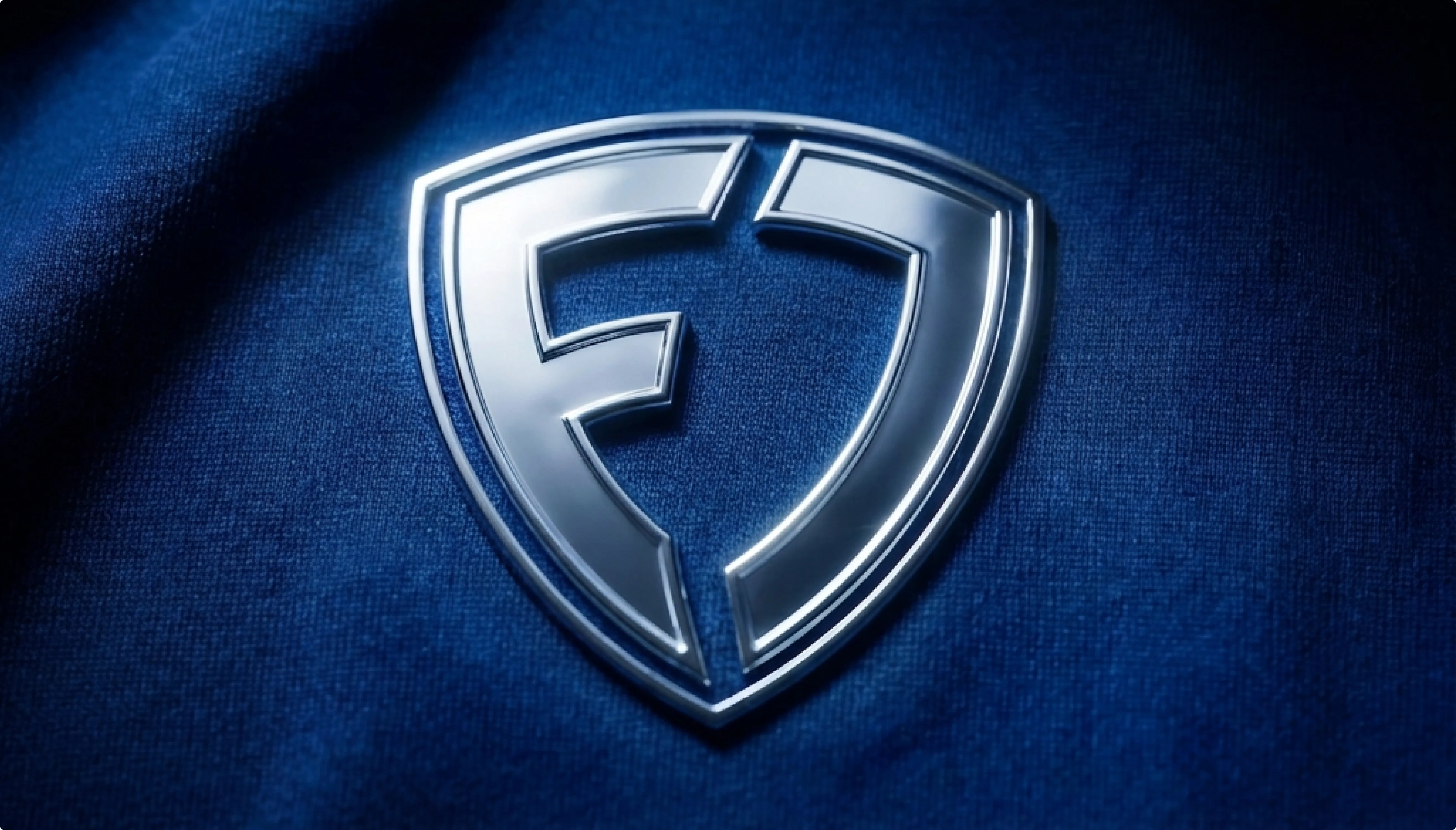 The FanDuel shield mark embossed in chrome on dark blue fabric