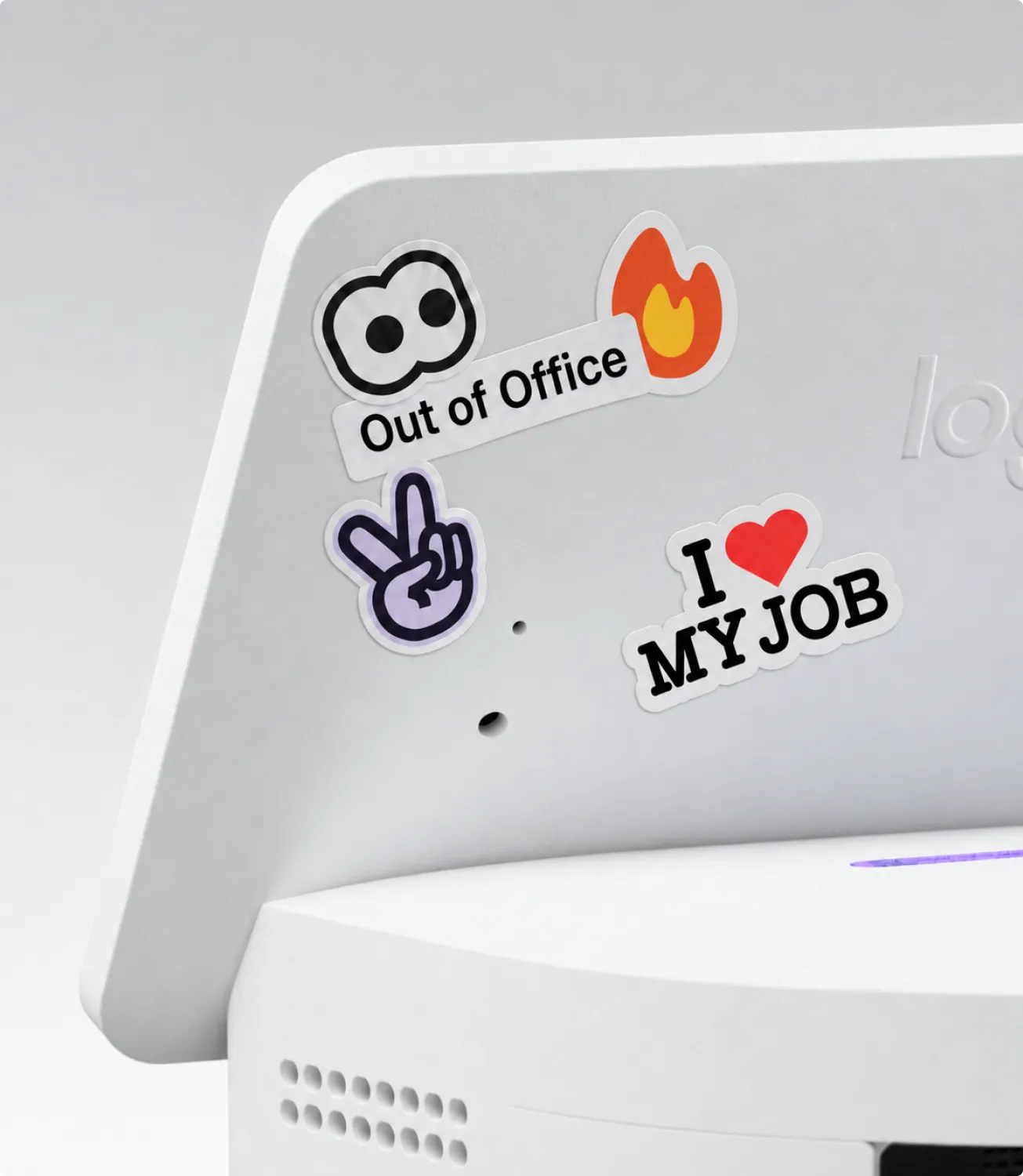 Stickers on the back of a Logi Dock Flex, among them Out of Office and I love my job