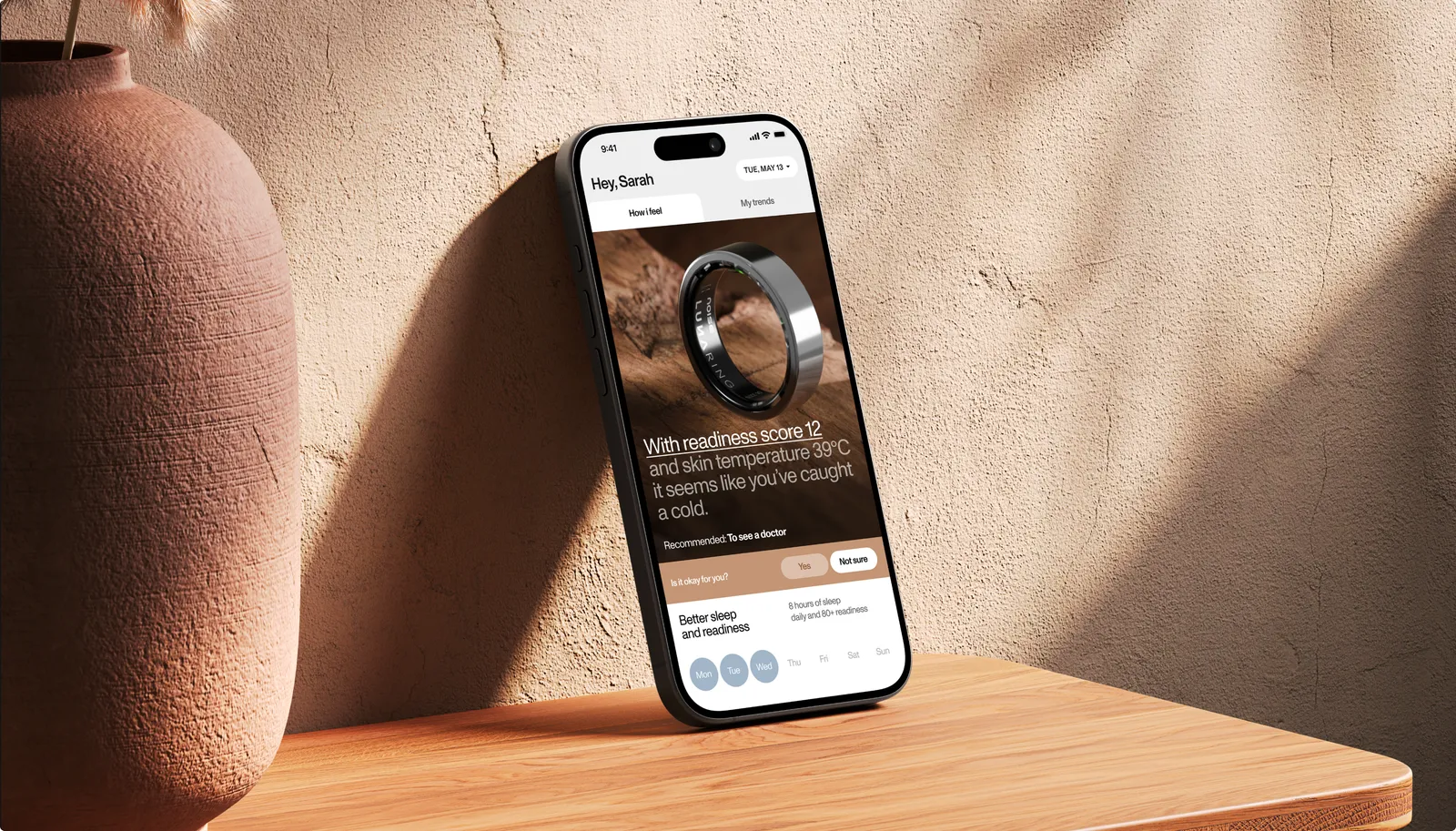 Phone leaning against a clay vase showing the Luna home screen with a readiness insight