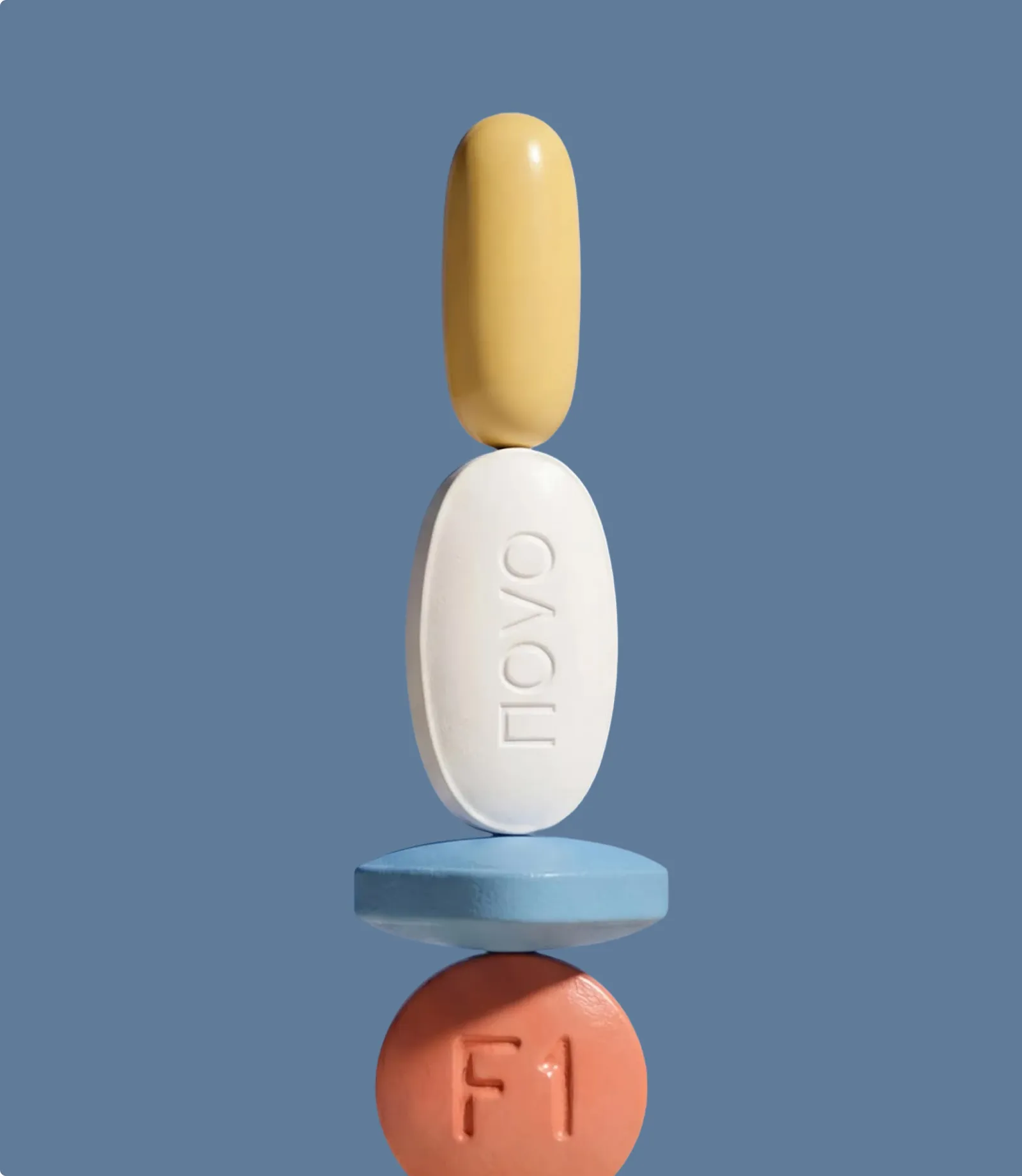 Stack of supplement capsules balanced on a blue background