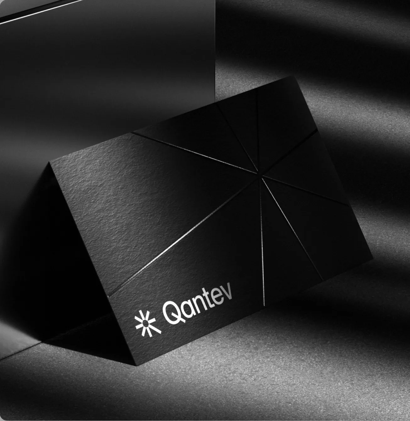 Black Qantev folder with an embossed asterisk mark and radial fold lines