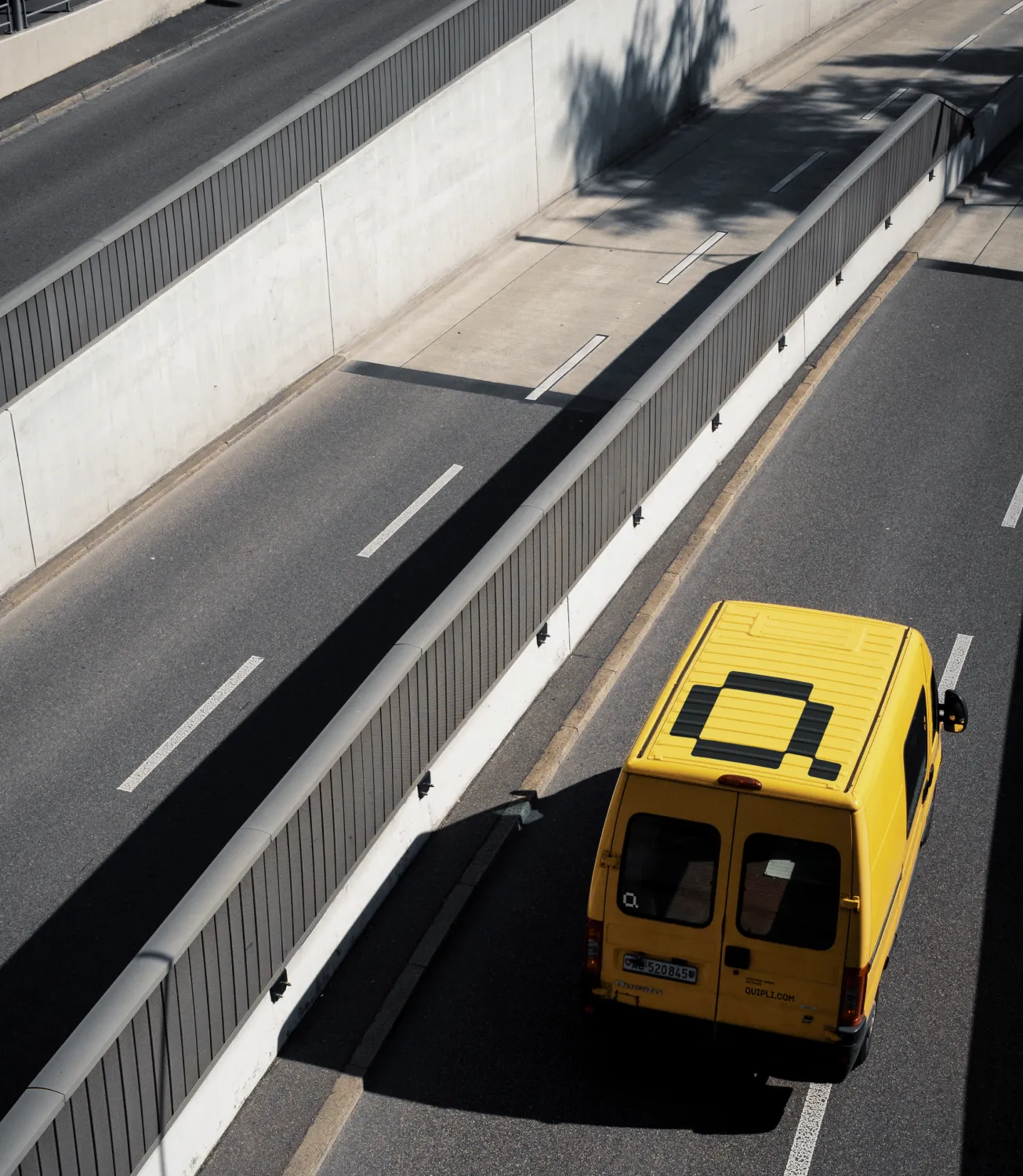 Yellow Quipli branded van seen from above driving along a highway