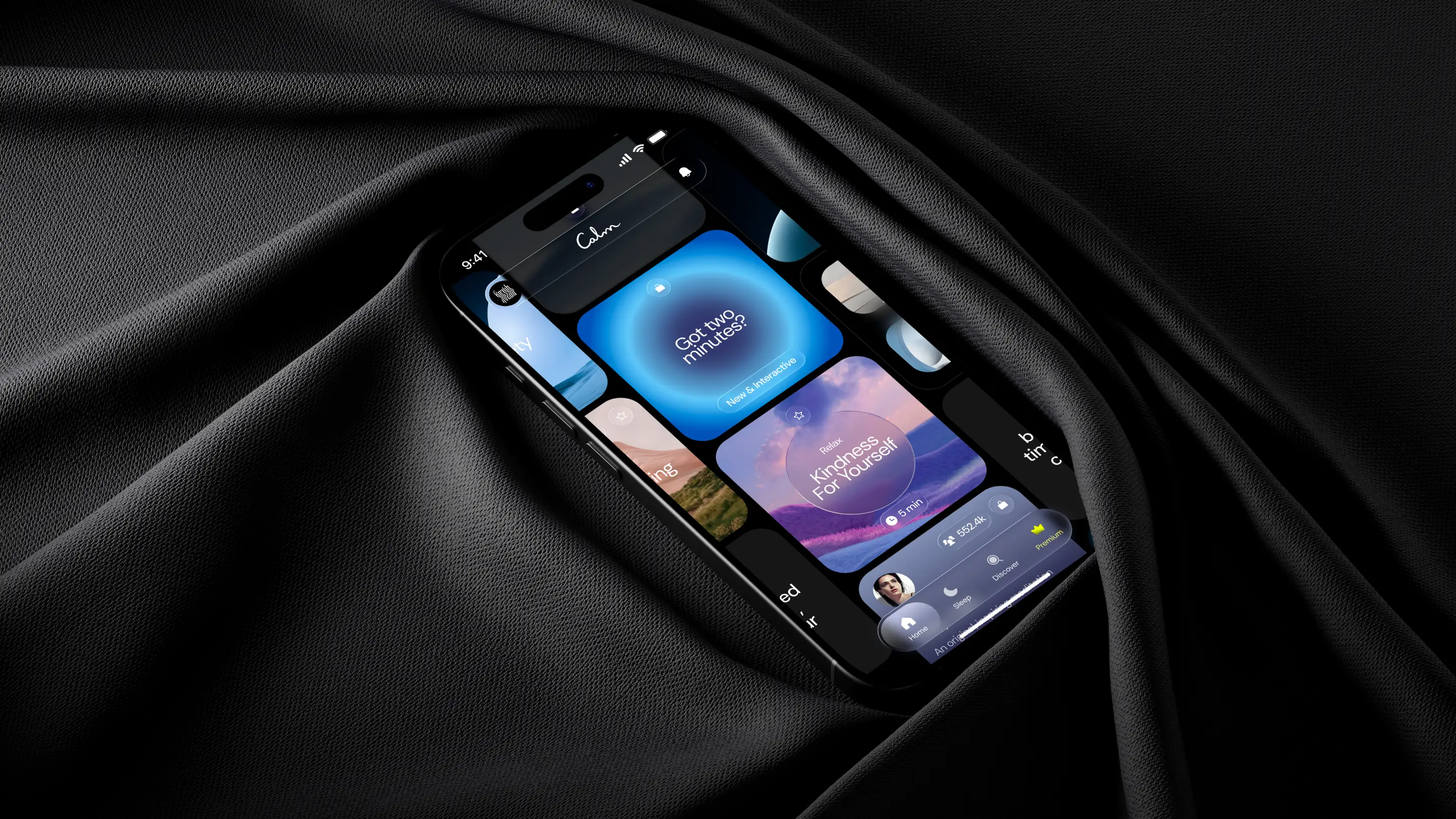 Phone with Calm app screens resting in folds of black fabric